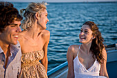 Two Young Women and Young Man Relaxing on Boat