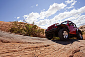 Jeep Driving on Red Rocks, Low Angle View, Moab, Utah, USA