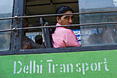 Passenger on a green public transportation bus in Delhi, India