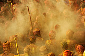 Throwing orange and yellow colors at the Nandgaon temple during Holi festival celebration, Nandgaon, Mathura, India