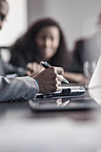 Businessman taking notes in meeting, Saint Louis, Missouri, USA