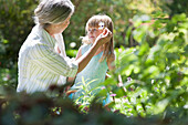 Grandmother and granddaughter picking flowers, Cape Town, Western Cape, South Africa