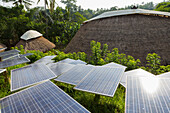 Solar panels among thatched roof buildings, Ubud, Bali, Indonesia