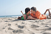 Caucasian couple laying on beach, Los Angeles, California, United States