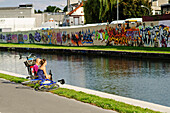 Couple looking at the graffitis on the walls along the Canal de l'Ourcq, Pantin, Seine-Saint-Denis, France