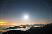 France, Hautes Pyrenees. Pic du Midi Observatory. Moon over the sea of ??clouds. Optical reflections.