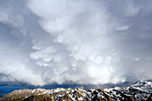 France, Hautes Pyrenees. The Pyrenees in a storm from the Pic du Midi Observatory. Mammatus cumulonimbus clouds and rainbows.