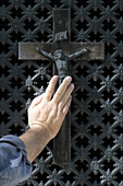 Hand on a crucifix. Paris. France.