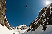 Austria, Kuhtaisnowboarder jumping a big gap between cliffs