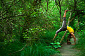 Woman practicing yoga in the forest, Landes, Hossegor