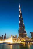 'Fountain display in front of the Burj Khalifa at sunset; Dubai, United Arab Emirates'