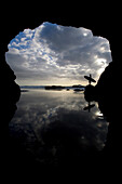 Silhouette Of Surfer On Beach Through Cave, Muriwai Beach, North Island, New Zealand