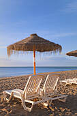 'Sun Umbrellas And Beach Beds On A Beach In Costa Del Sol; Torremolinos, Malaga, Andalusia, Spain'
