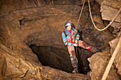 'Female Athlete Exploring A Cave; Fernie, British Columbia, Canada'