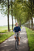 'A Boy Riding His Bike Along The Dutch Canals; Houten, The Netherlands'