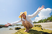'A Female Tourist Stretches Out Her Arms On The Beach Of A Tropical Island; Koh Lanta, Krabi Province, Thailand'