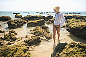 'A Woman Tourist Enjoys The Sunshine On The Beach Of A Tropical Island; Koh Lanta, Thailand'
