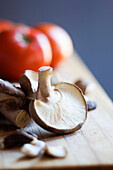 Portobello Mushrooms With Tomatoes On A Wooden Cutting Board