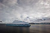 'Iceberg in the ocean and snow covered mountains along the coastline;Antarctica'