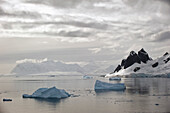 'Icebergs and mountains along the coastline;Antarctica'