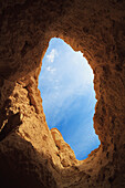 'A opening in a cave looking up to the blue sky;Israel'