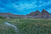 'Early morning in badlands national park with deer on a ridge silhouetted against the brightening sky; south dakota united states of america'