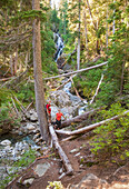 'A mature couple at a waterfall on a hike in to rainbow lake;Whistler british columbia canada'