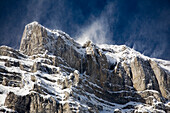 'Snow covered mountain peak with blowing snow off the peak and blue sky;Banff alberta canada'