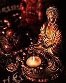 'Statues Of Buddha Illuminated By A Single White Candle In A Dark Environment; California, United States Of America'