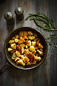 Crunchy potatoes with rosemary in an old iron pan