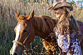 'A woman walking with her horse; Hawaii, United States of America'