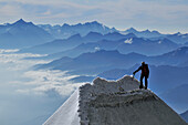 Mountaineer climbing a cornice on the ridge of Tour Ronde, Mont Maudit, Mont Blanc Group, France