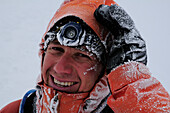 Bergsteiger, stark vereist, während Schneesturm am Nadelgrat, Nadelhorn (4327 m), Wallis, Schweiz