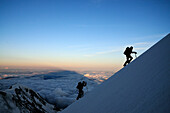Mountaineers in the shadow of Mont Blanc during ascent of Aiguille de Bionnassay, Mont Blanc, France