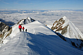 Bergsteiger während des Anstiegs zum Dome de Gouter, Aiguille du Bionnassay im Hintergrund, Mont Blanc Massiv, Frankreich