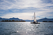 Sailing boat and view over Chiemsee to Fraueninsel, near Gstadt, Chiemsee, Chiemgau region, Bavaria, Germany