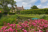 View from the rose garden across the lily pond to the manor house, Bateman's, home of the writer Rudyard Kipling, East Sussex, Great Britain