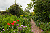 Blick über den Garten zur Dorfkirche, Monk's House, Haus der Schriftstellerin Virginia Woolf, Rodmell, East Sussex, Großbritannien