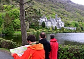 Drei Männer bei Kylemore Abbey im Connemara, Irland