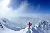 Frau steigt zum Piz Zuort auf, Piz Plavna Dadora im Hintergrund, Piz Zuort, Sesvennagruppe, Engadin, Graubünden, Schweiz