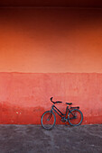 Cycle leaning against a red wall, Marrakech, Morocco