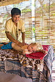 Little boy getting back massage, Balinese masseur, boy 3 years old, wellness, hotel, intercultural contact, meeting local people, locals, Balinese holiday resort, family travel in Asia, parental leave, German, European, MR, Sidemen, Bali, Indonesia