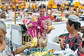 Mother with baby, little children, baby sling, wrap, girl 5 months old, boy 3 years old, son, market, talking with market women, selling offerings, intercultural contact, meeting local people, locals, family travel in Asia, parental leave, German, Europea