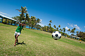 Dorfjungen spielen Fußball auf Feld mit Palmen im Hintergrund, Insel Sawa-i-Lau, Yasawa-Inseln, Fidschi-Inseln, Südpazifik