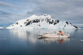 Expeditions-Kreuzfahrtschiff MS Hanseatic (Hapag-Lloyd Kreuzfahrten) vor eisbedeckter Bergkulisse, Lemaire Kanal, nahe Grahamland, Antarktis