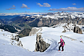 Female back-country skier ascending in Val Culea, Val Gardena and Geisler Group in background, Sella Group, Dolomites, South Tyrol, Italy
