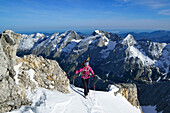 Frau auf Skitour steigt durchs Schlauchkar zur Birkkarspitze auf, Karwendelkette im Hintergrund, Karwendel, Tirol, Österreich