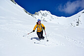 Female back-country skier downhill skiing from Grosser Moeseler, Zillertal Alps, South Tyrol, Italy