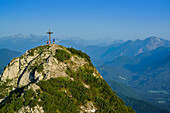 Hikers beside summit cross of Rossstein, Bavarian Prealps, Upper Bavaria, Bavaria, Germany