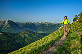 Woman hiking along a small track, Karwendel range in background, Blauberge, Bavarian Prealps, Upper Bavaria, Bavaria, Germany